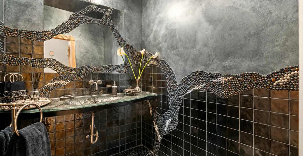 black marbled bathroom with unique beaded wall design