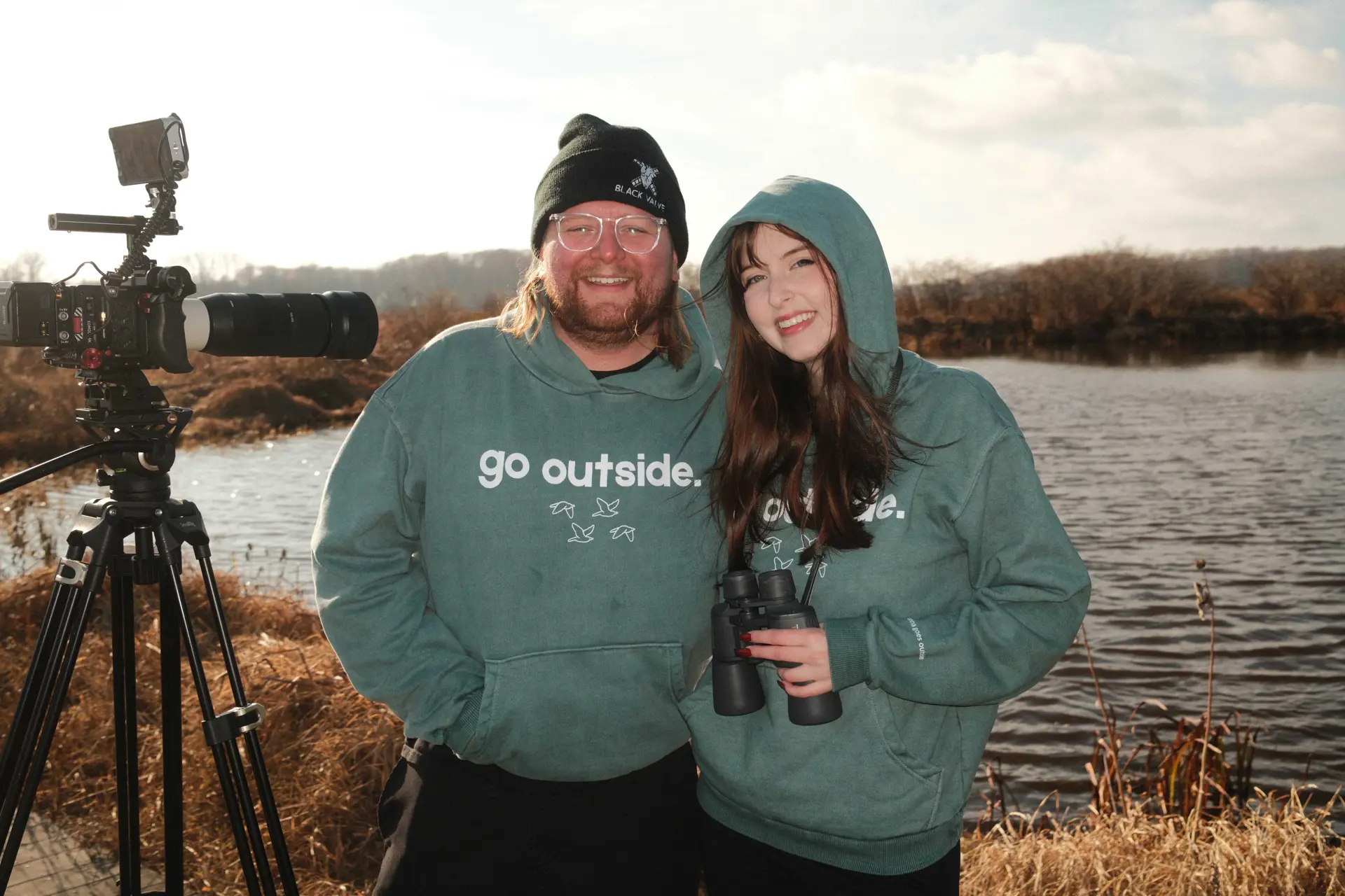 Anna Henry and Evan Prunty pose in front of a waterfront