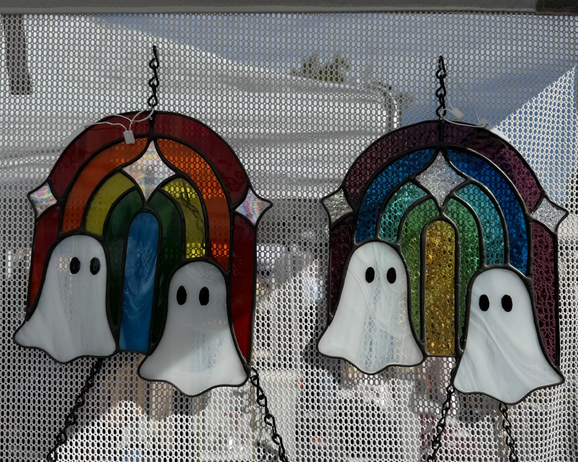 stained glass wall hanging of ghosts in front of a rainbow