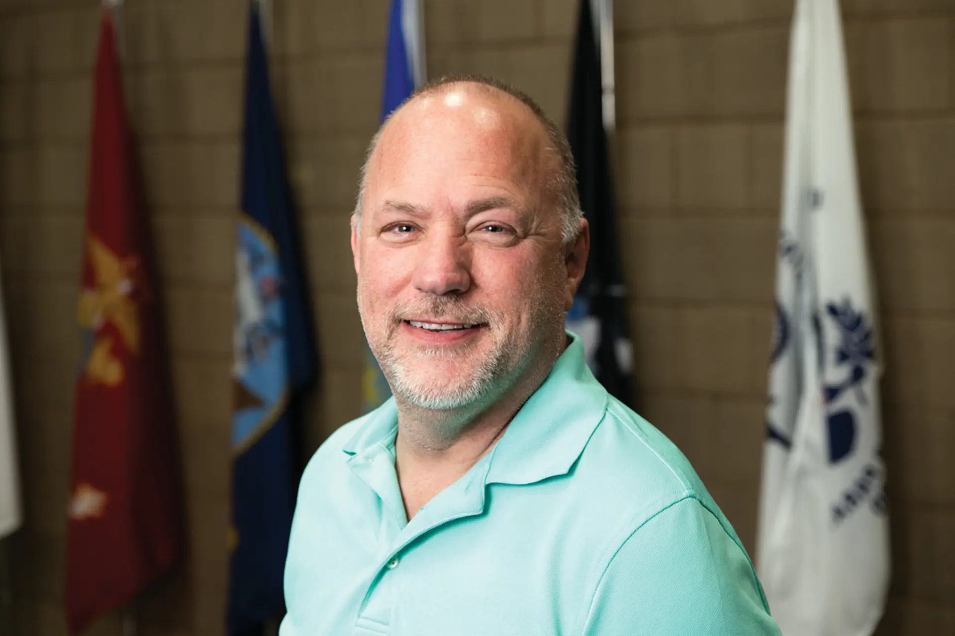 a man in teal smiling