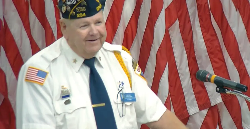 a man smiling behind a podium