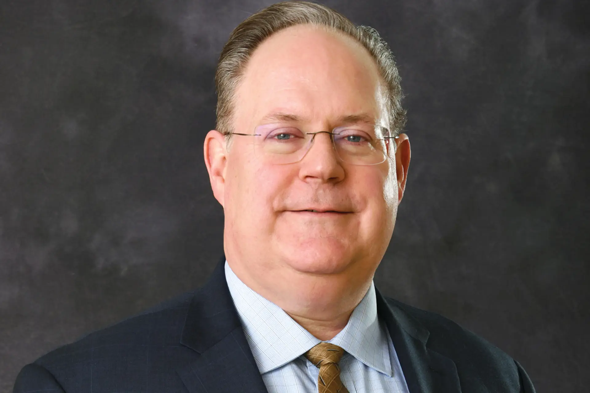 a man in glasses smiling