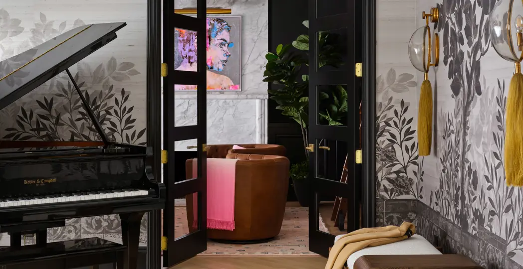 Music room with glass-domed Arteriors sconces hanging off a gray-and-white mural-papered wall