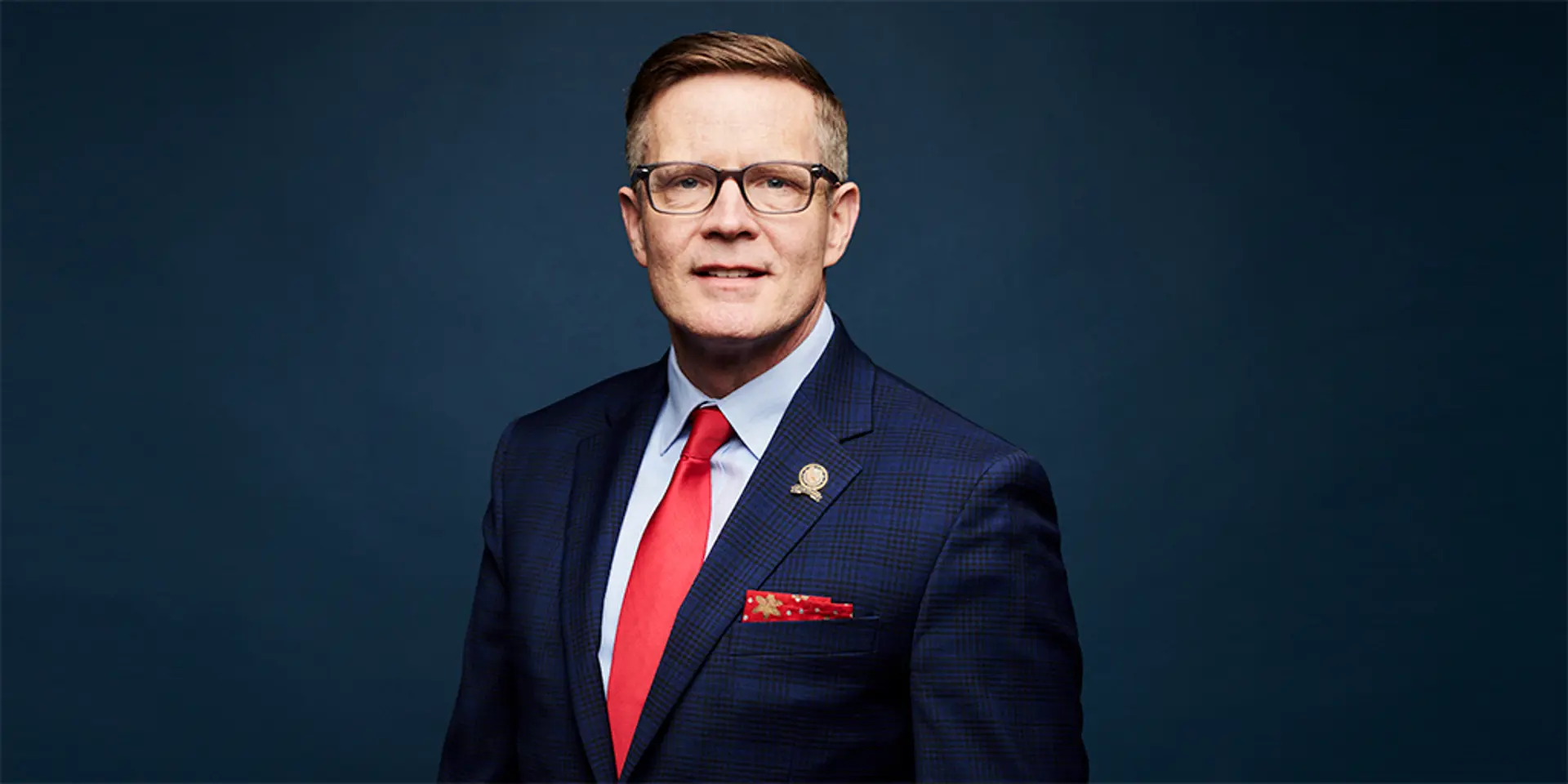 Kevin Kelley portrait, man in a suit and glasses.