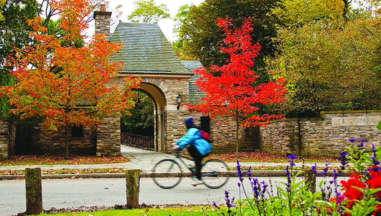 A bicyclist rides by the entrance to Frick Park in Pittsburgh, Pennsylvania (photo courtesy of Pittsburgh Parks Conservancy) A bicyclist rides by the entrance to Frick Park in Pittsburgh, Pennsylvania (photo courtesy of Pittsburgh Parks Conservancy)