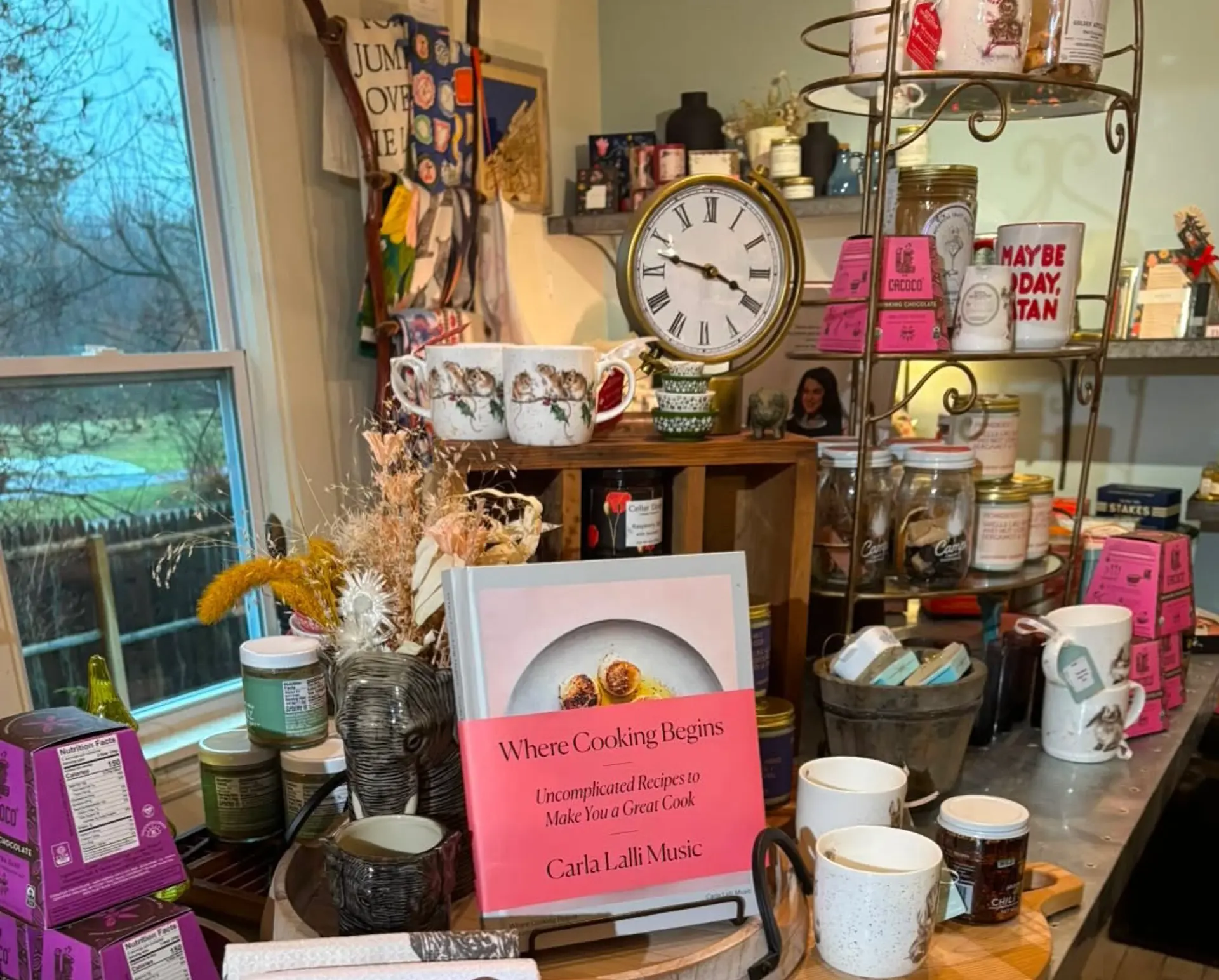 display shelf with cookbooks and mugs