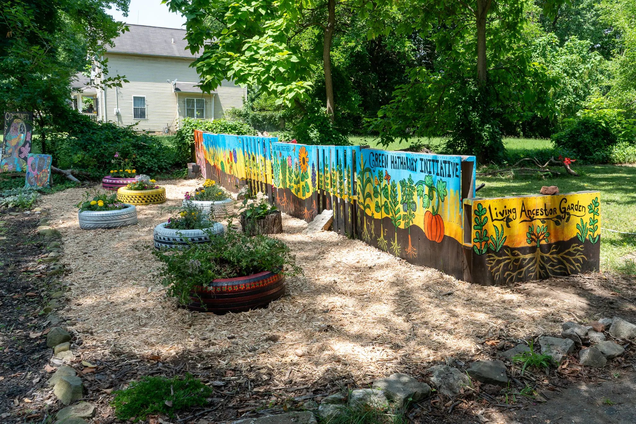 painted fence and tire plant beds