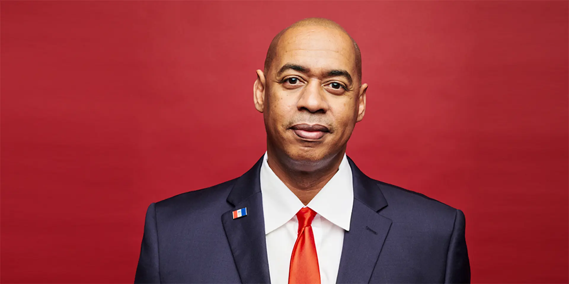 Portrait of a man with a red background.