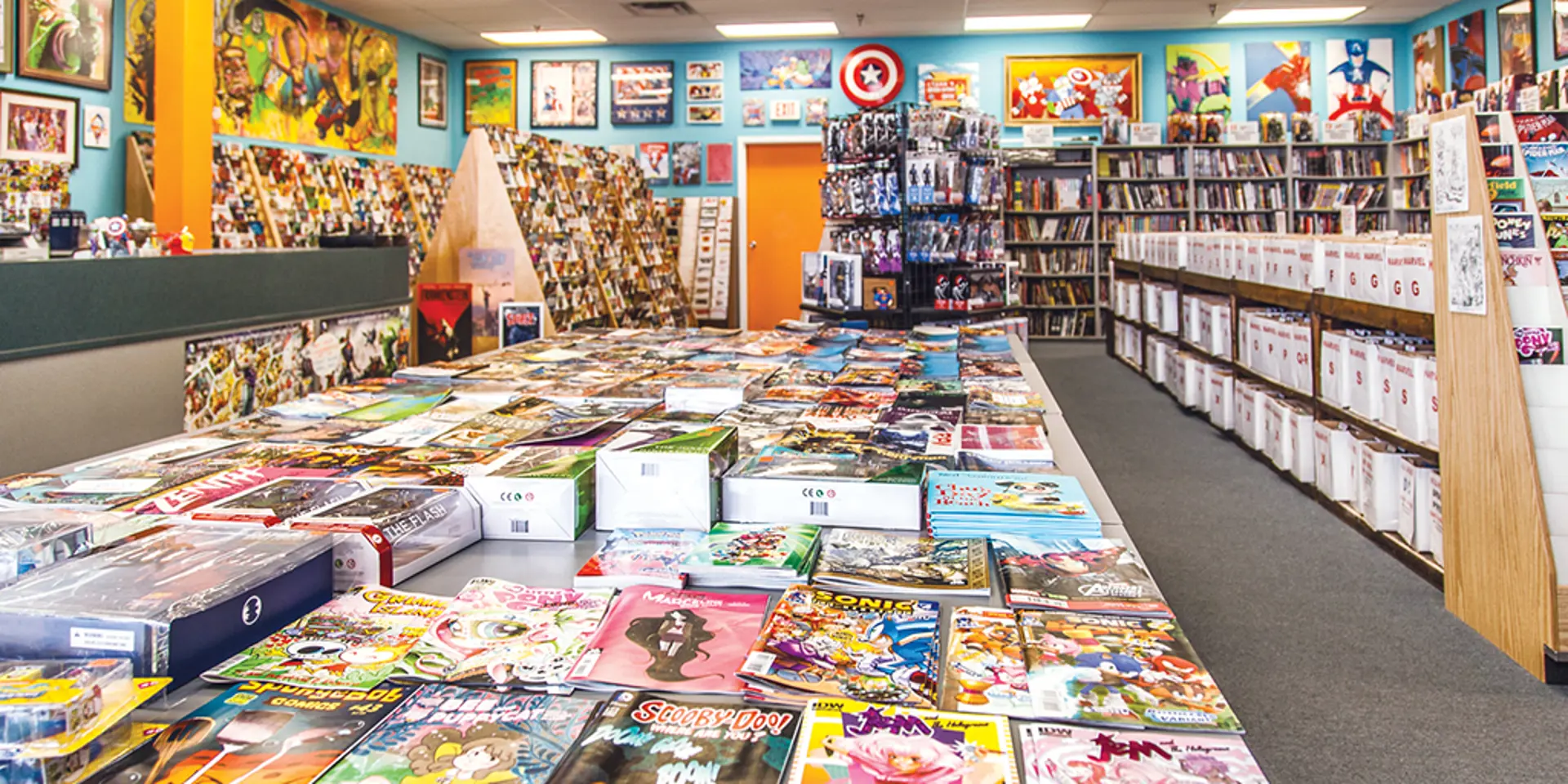 The big table at Carol & John’s Comic Book Shop is always laden with comics, as are the all-ages corner and the graphic novel selection.