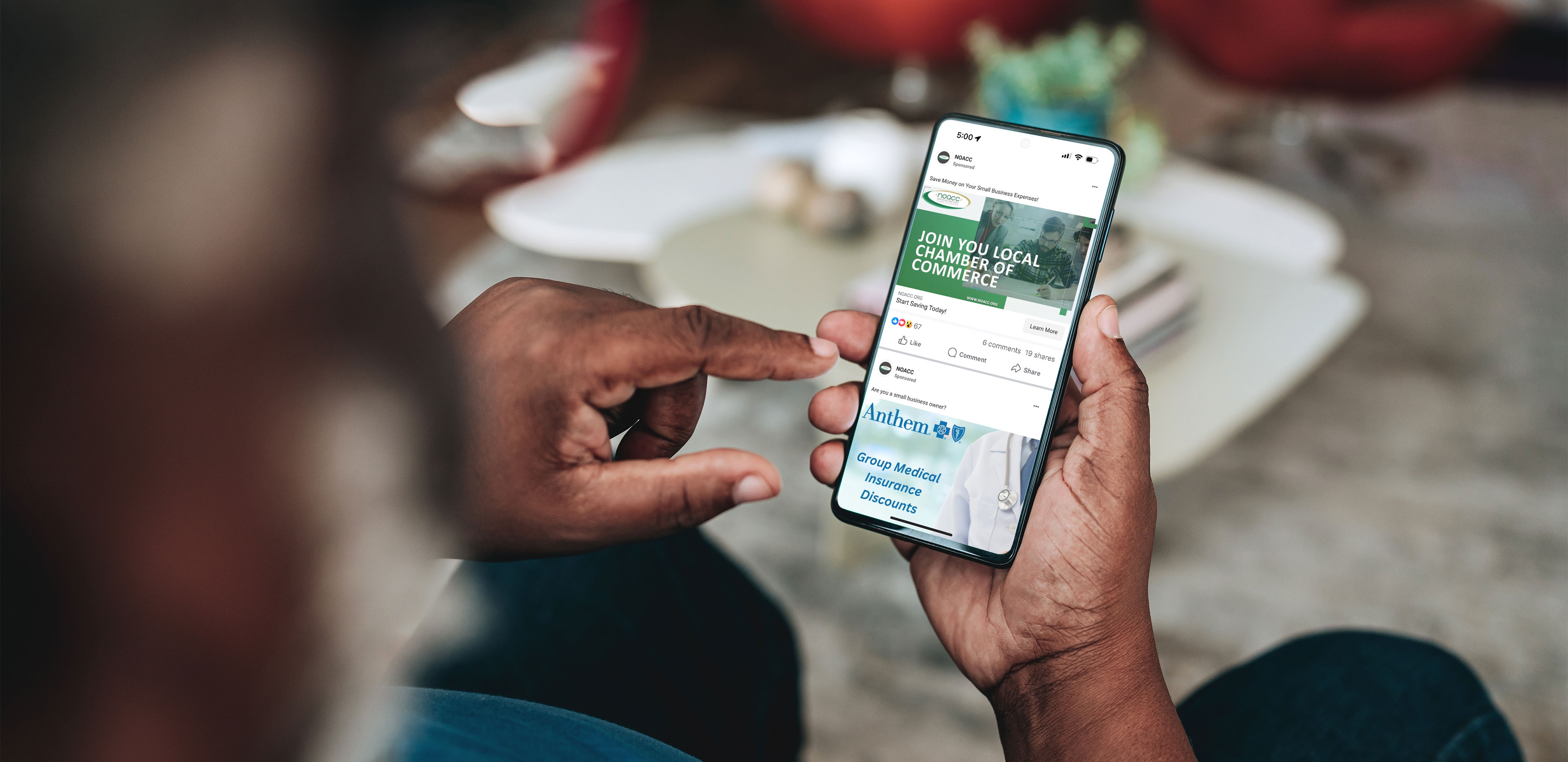 A man's hands holding a phone displaying NOACC Facebook ads A man's hands holding a phone displaying NOACC Facebook ads
