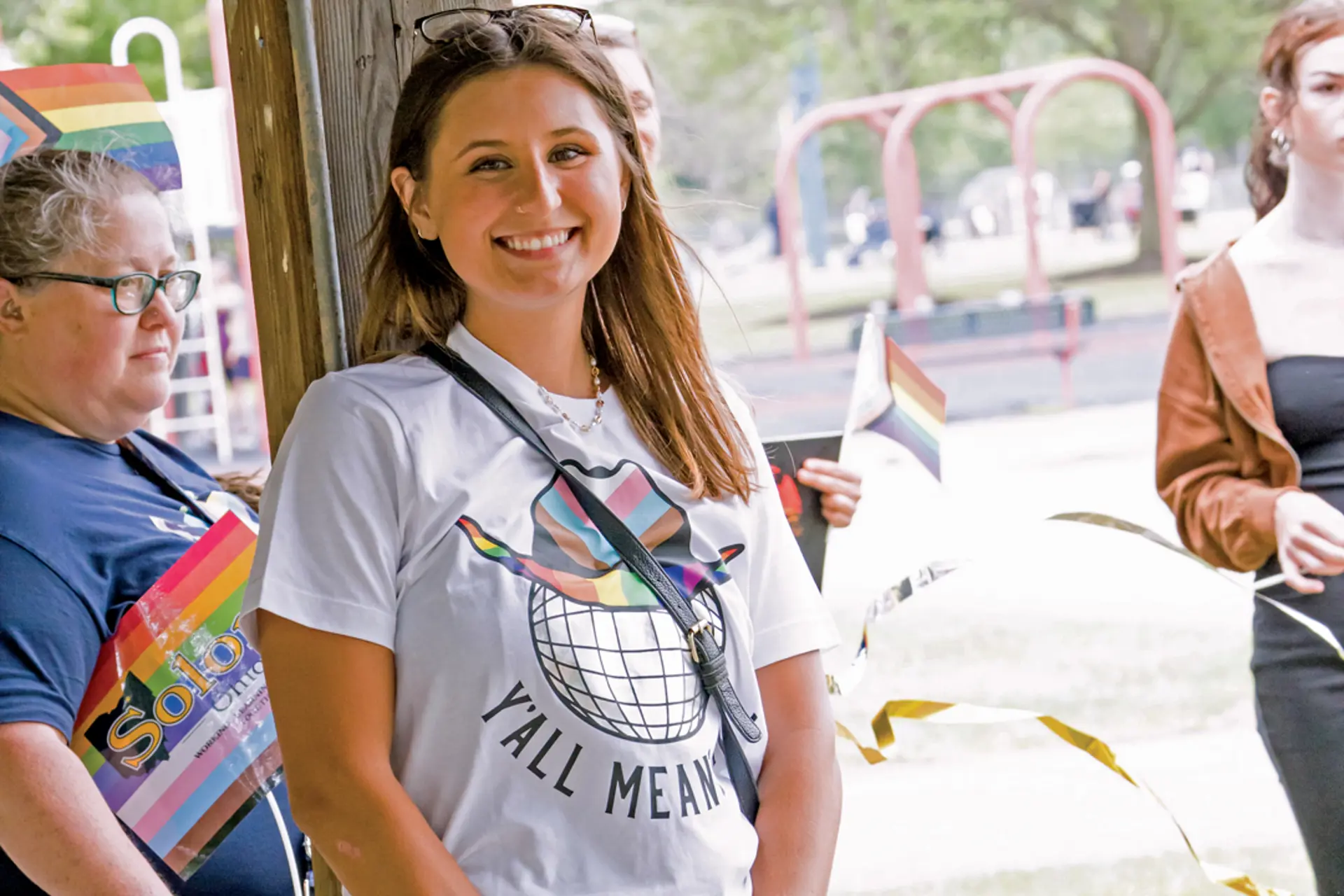 A woman smiling and wearing a Pride shirt