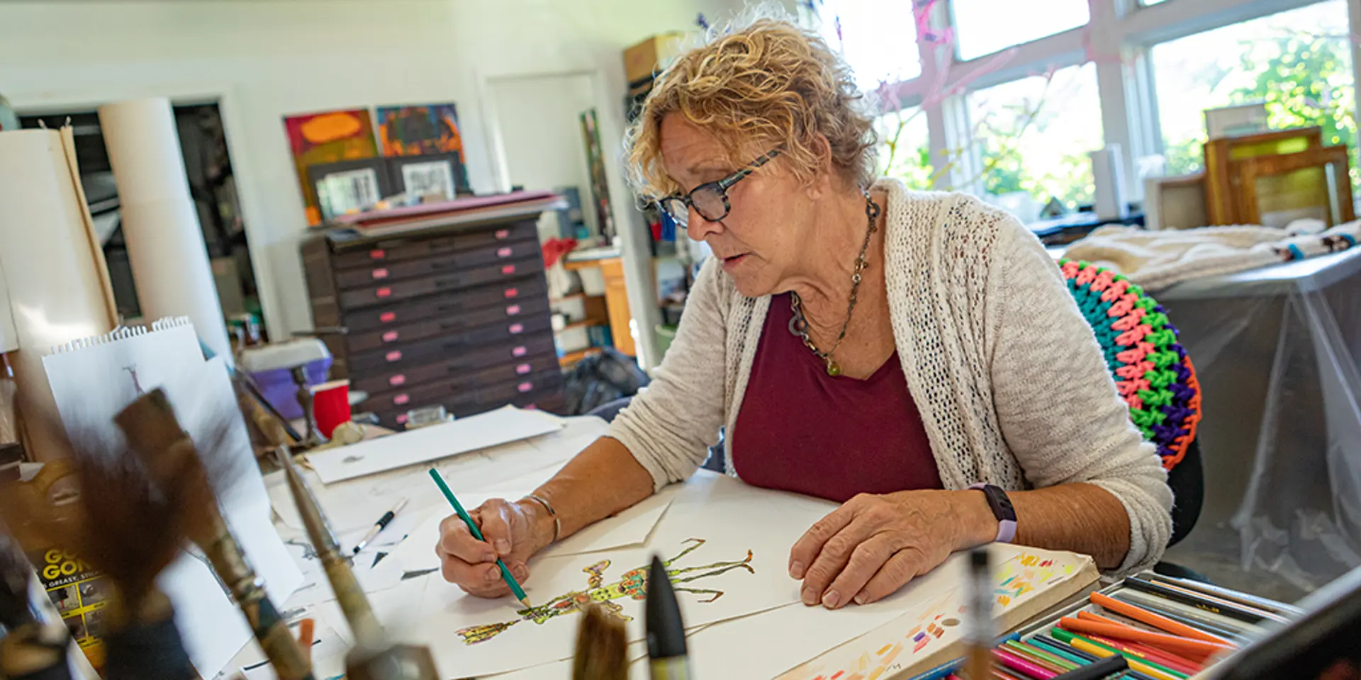 Carol Hummel drawing in an art studio.