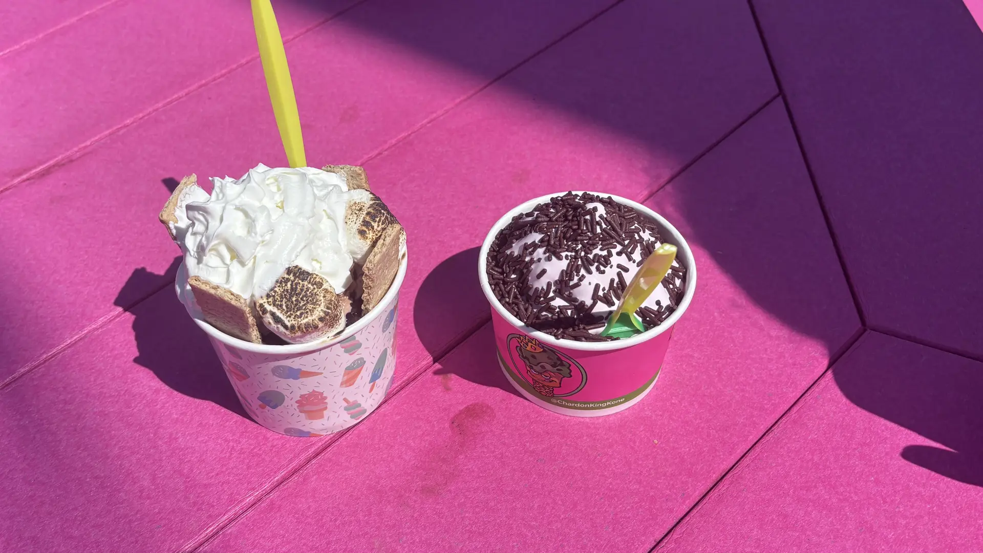two cups of ice cream on a pink table