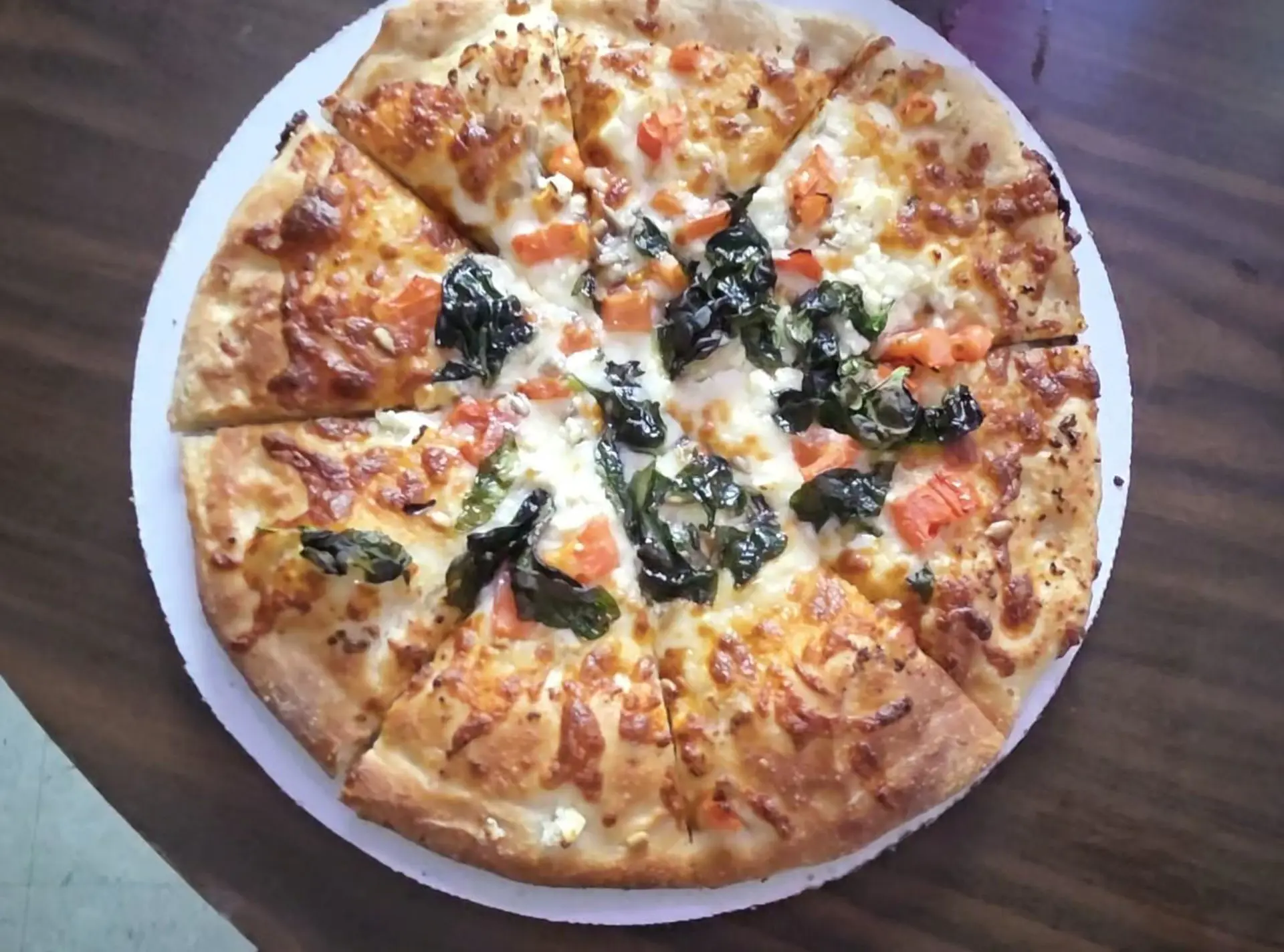 Pizza topped with basil and tomatoes