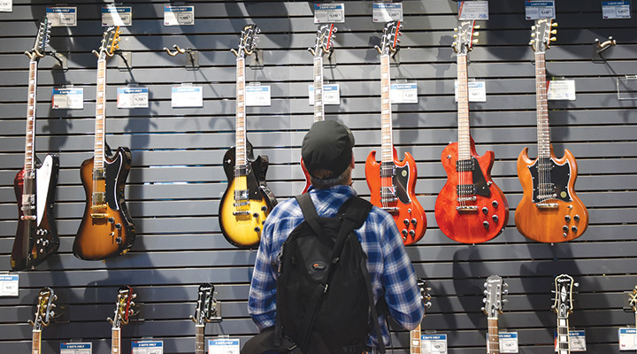 Man looking at guitars at Sweetwater in Fort Wayne, Indiana (photo courtesy of Visit Fort Wayne)