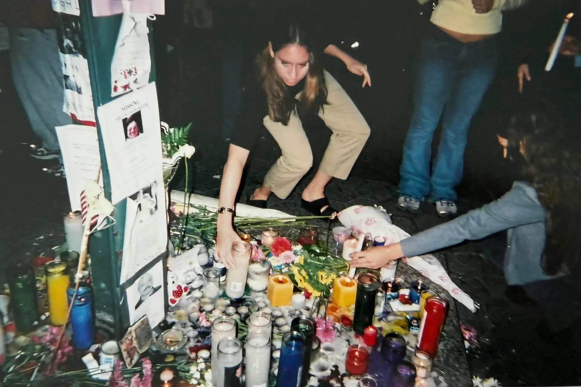 Woman putting a candle down at a tribute for 9/11.