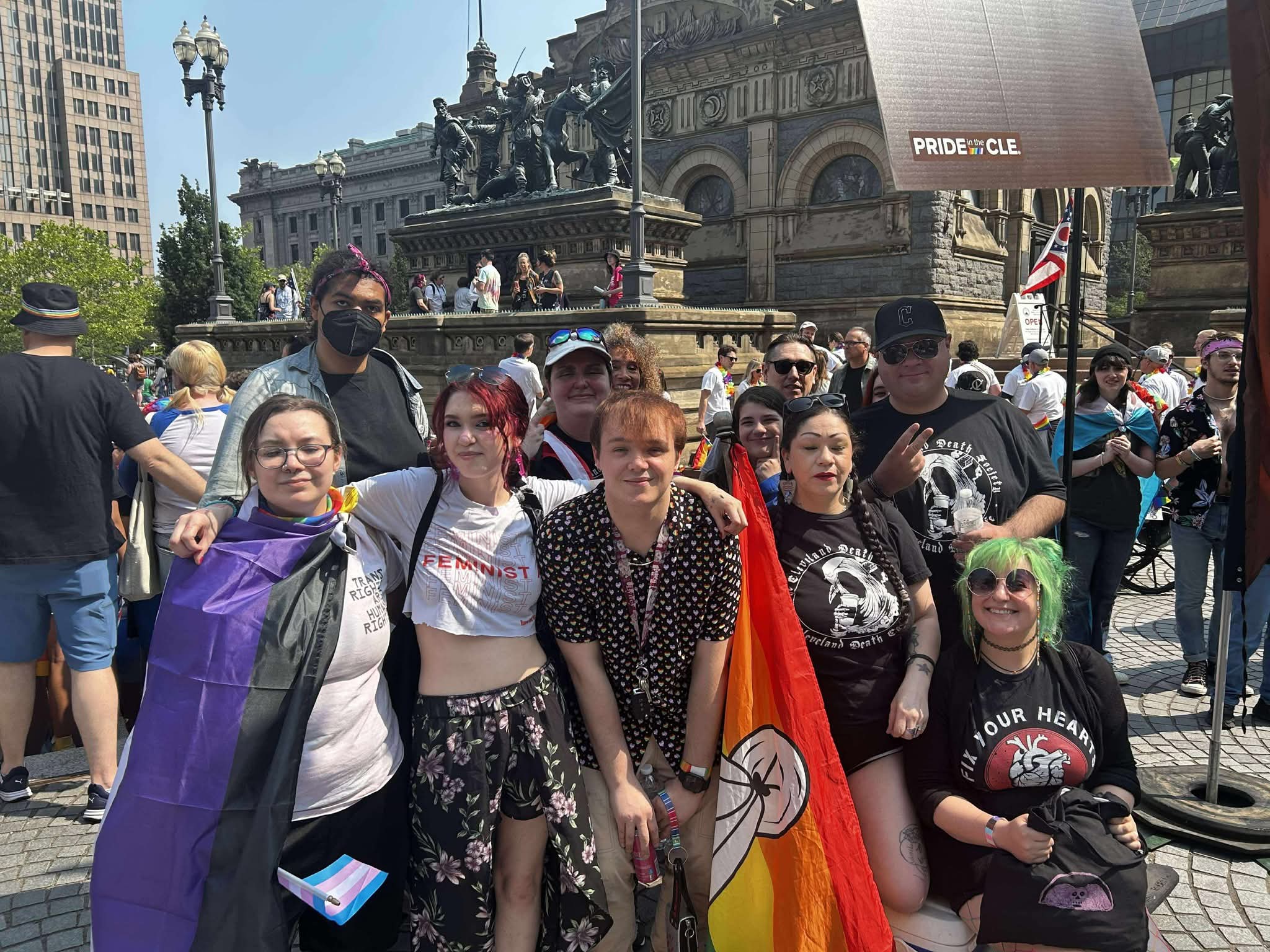 Group of participants pose for a photo in a city Pride event.
