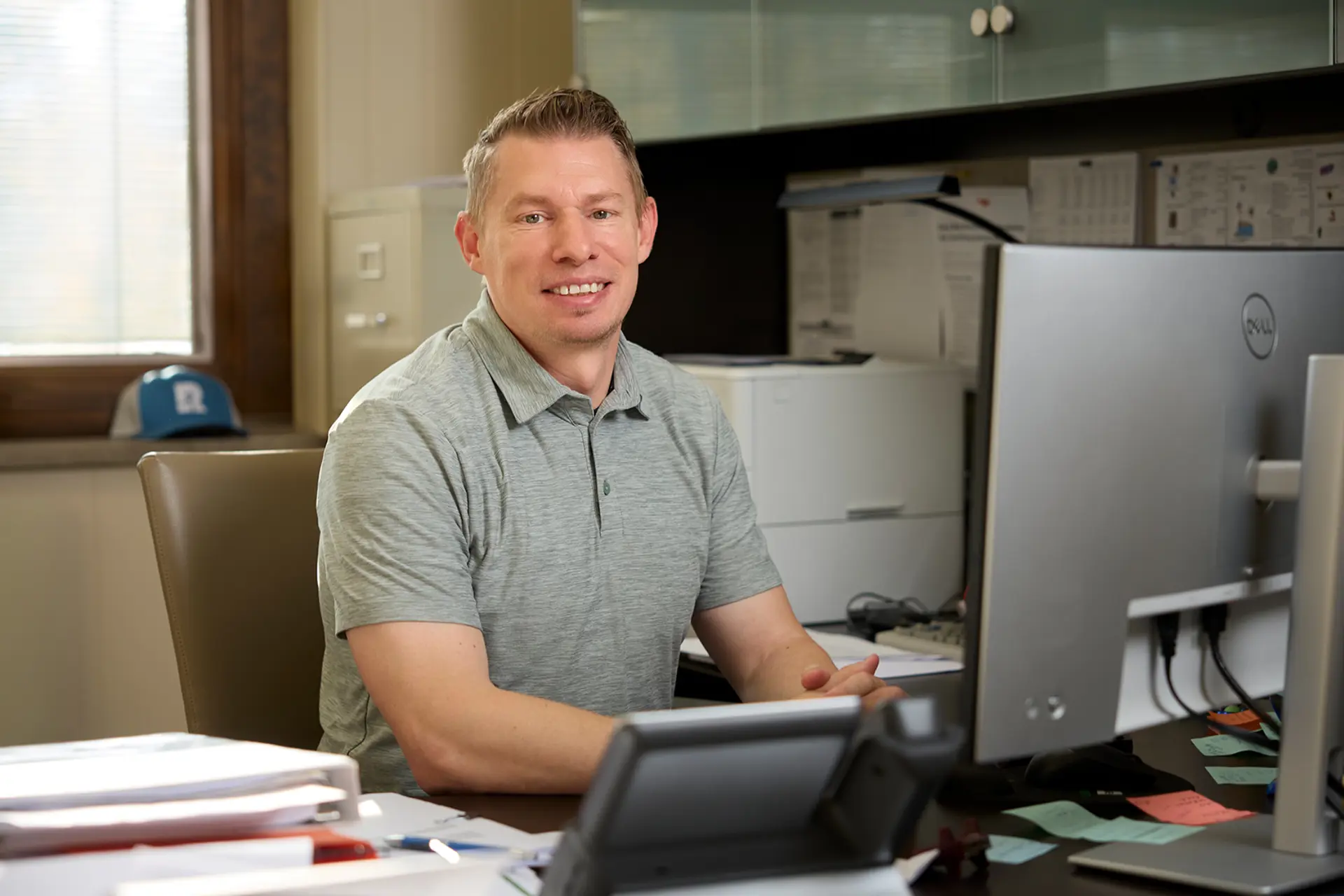 Jonathan Lindow smiling and sitting at his desk