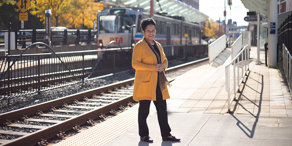 Woman posing in front of a train.