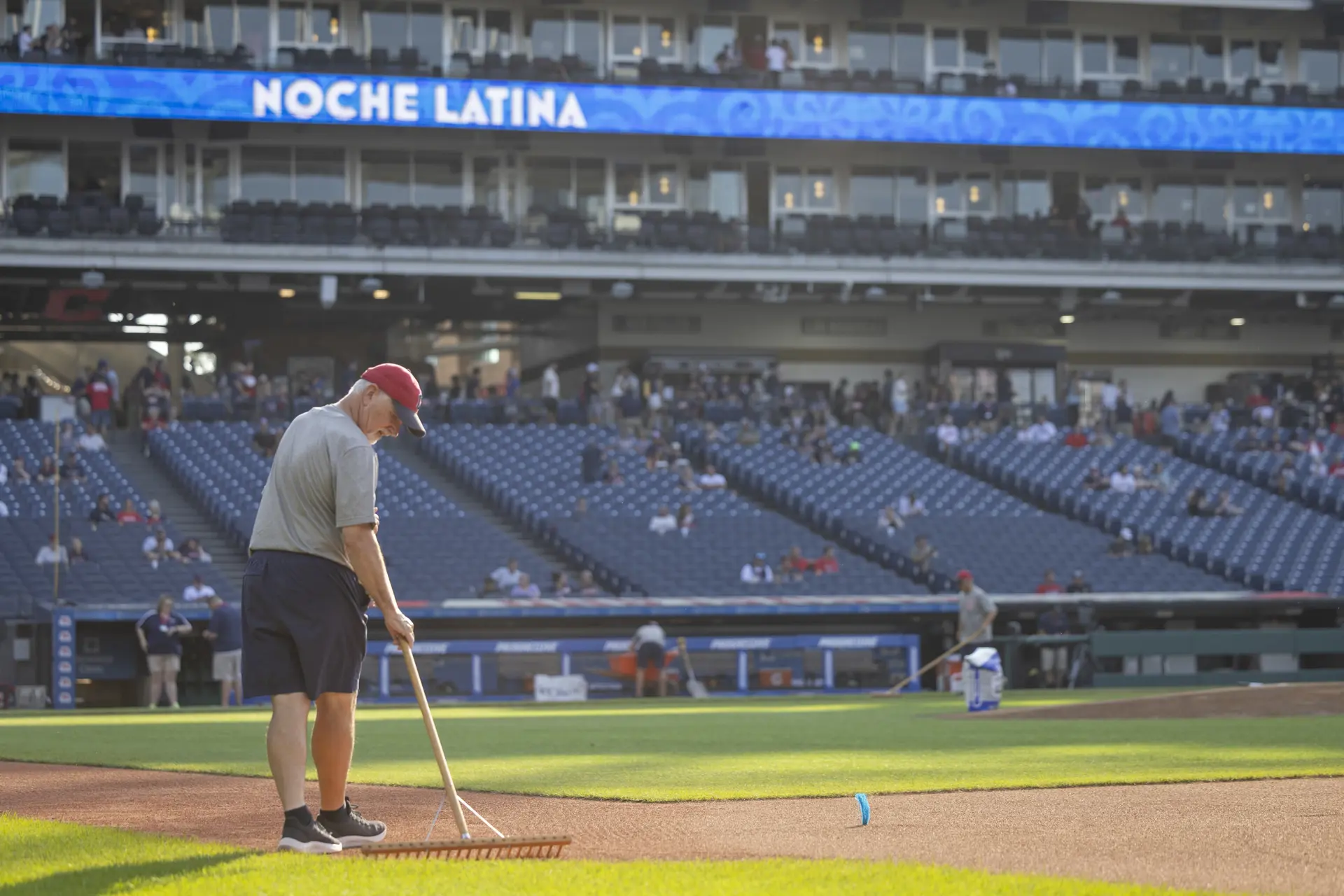 A sole Guardians' groundskeeper rakes the infield.