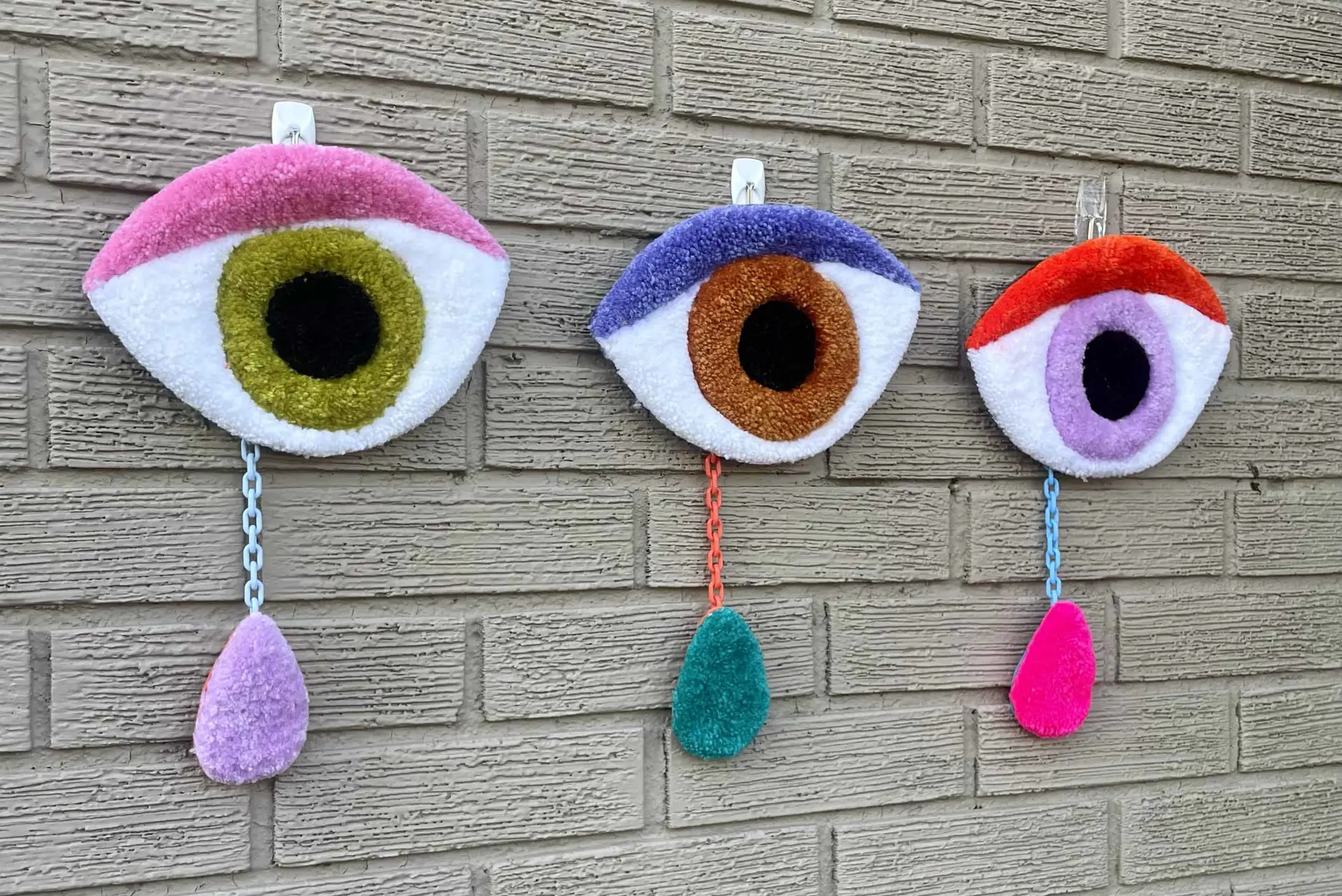 tufted wall hangings of eyes