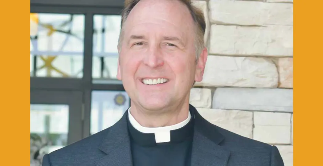 A priest smiling