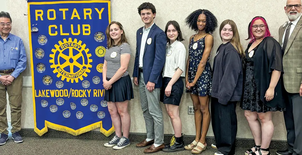 Scholarship-awarded students smiling with Rotary Club members