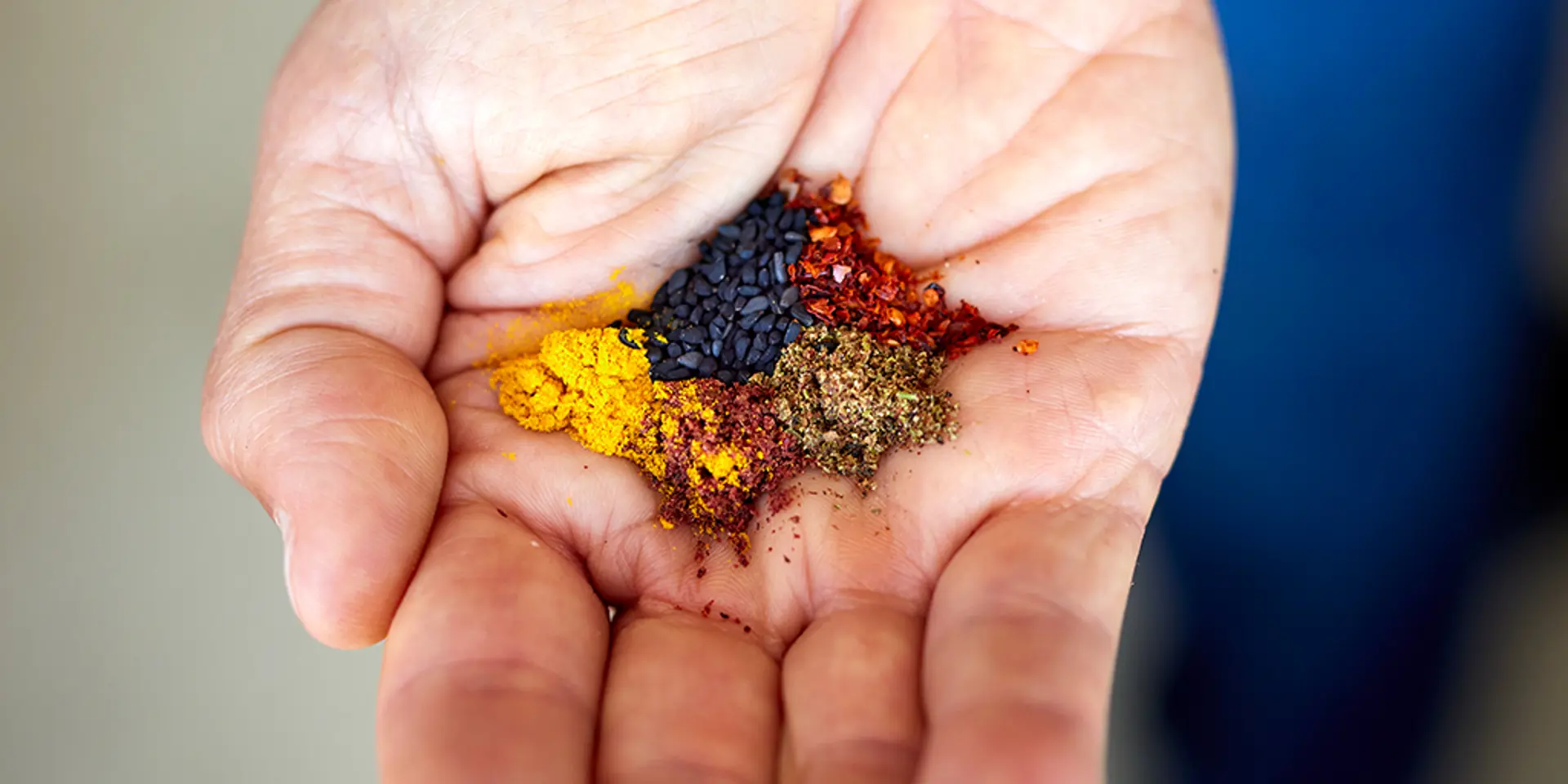 A hand holding a mix of colorful spices.