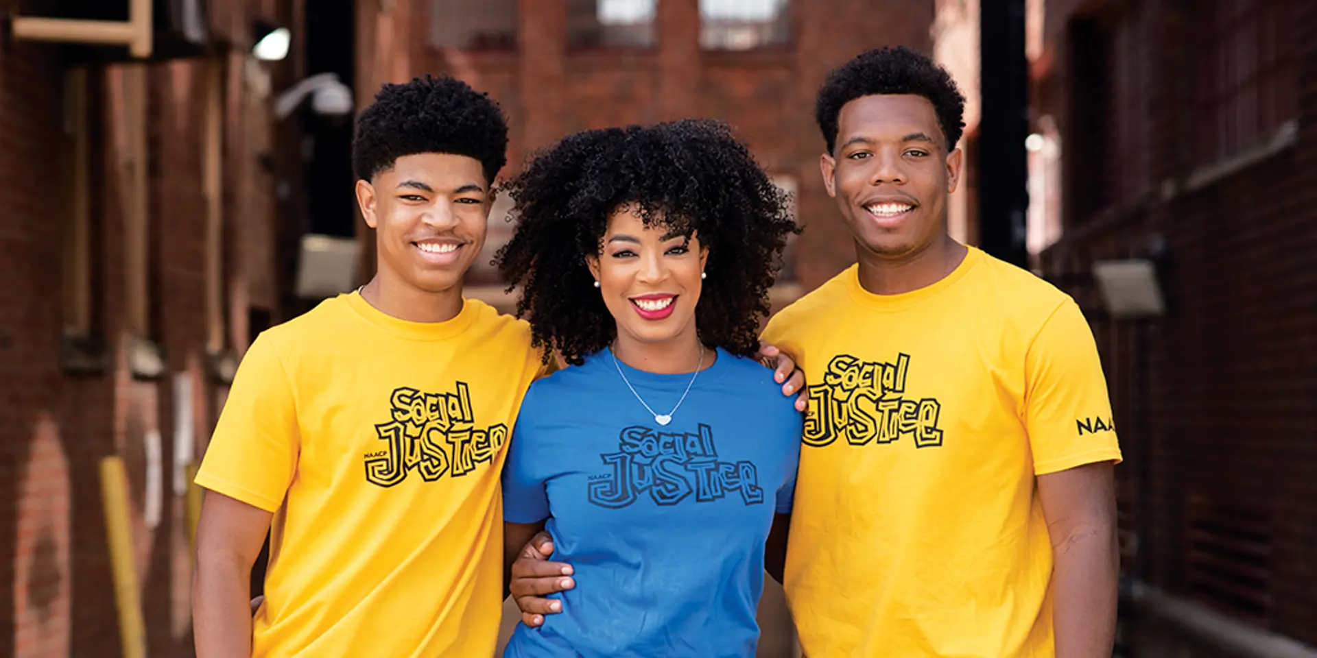 Three people smiling.