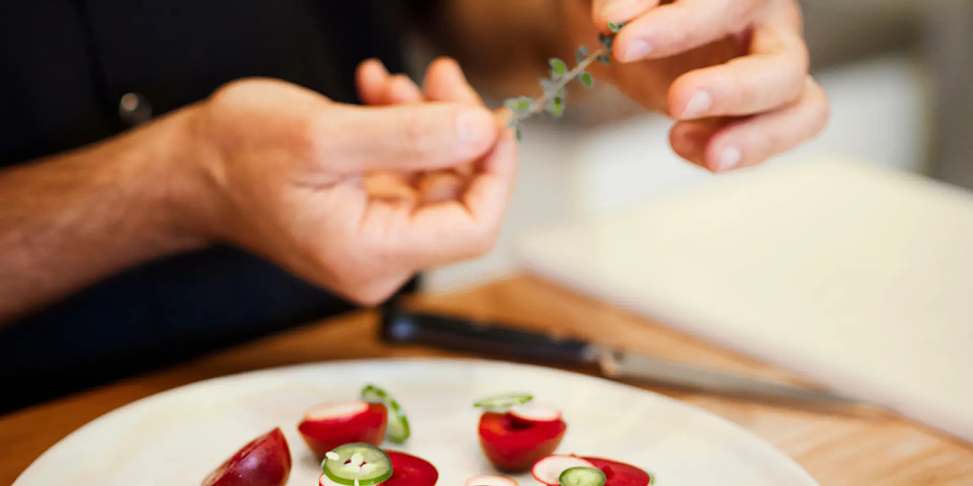 Hands pulling spice leaves off a stem