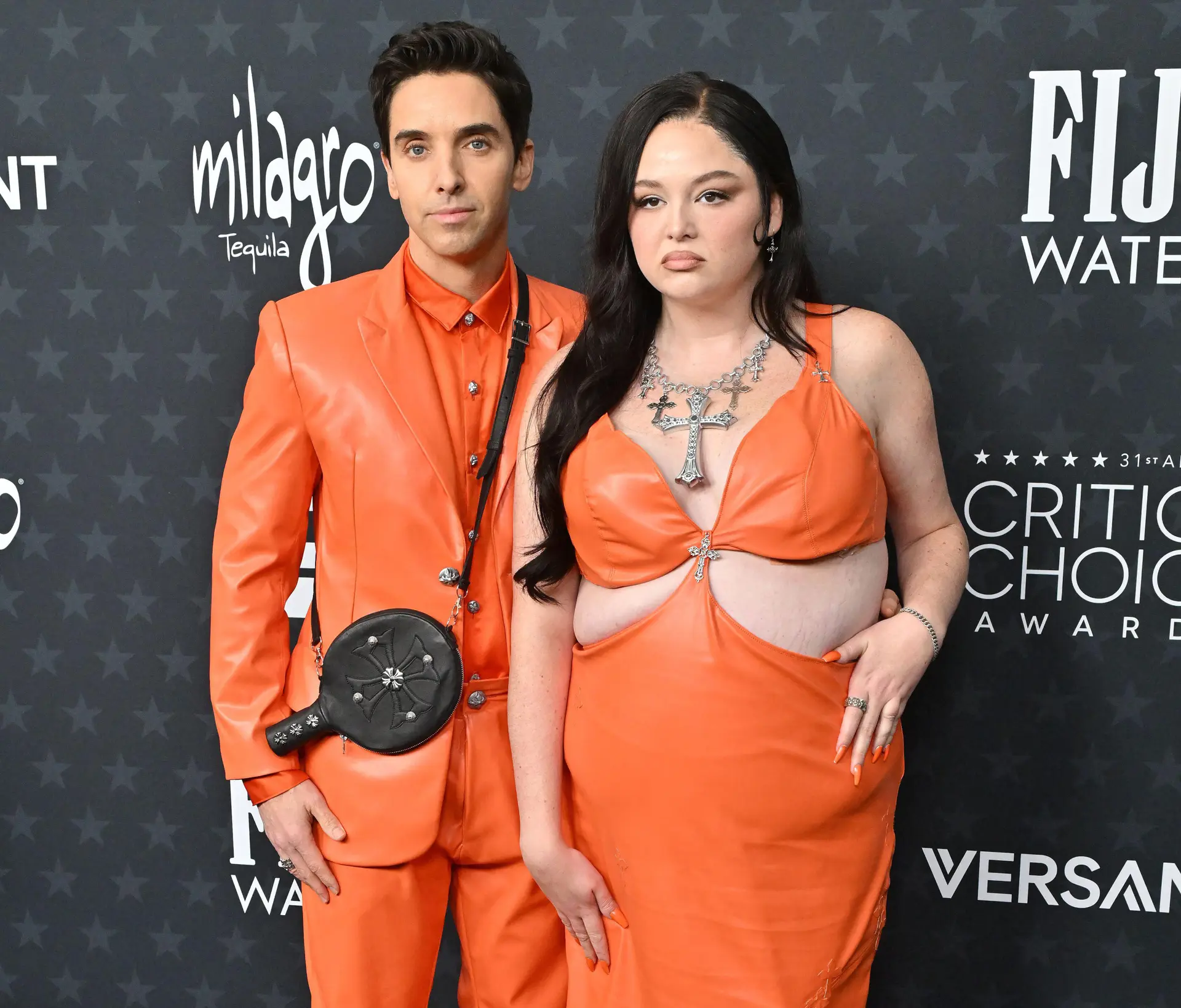 Megan Stalter and Paul W. Downs in orange outfits.